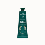 A squeeze tube of The Body Shop Vanilla Hand Balm, featuring a dark teal-green color with white text and a matching green cap, centered on a solid cream background.