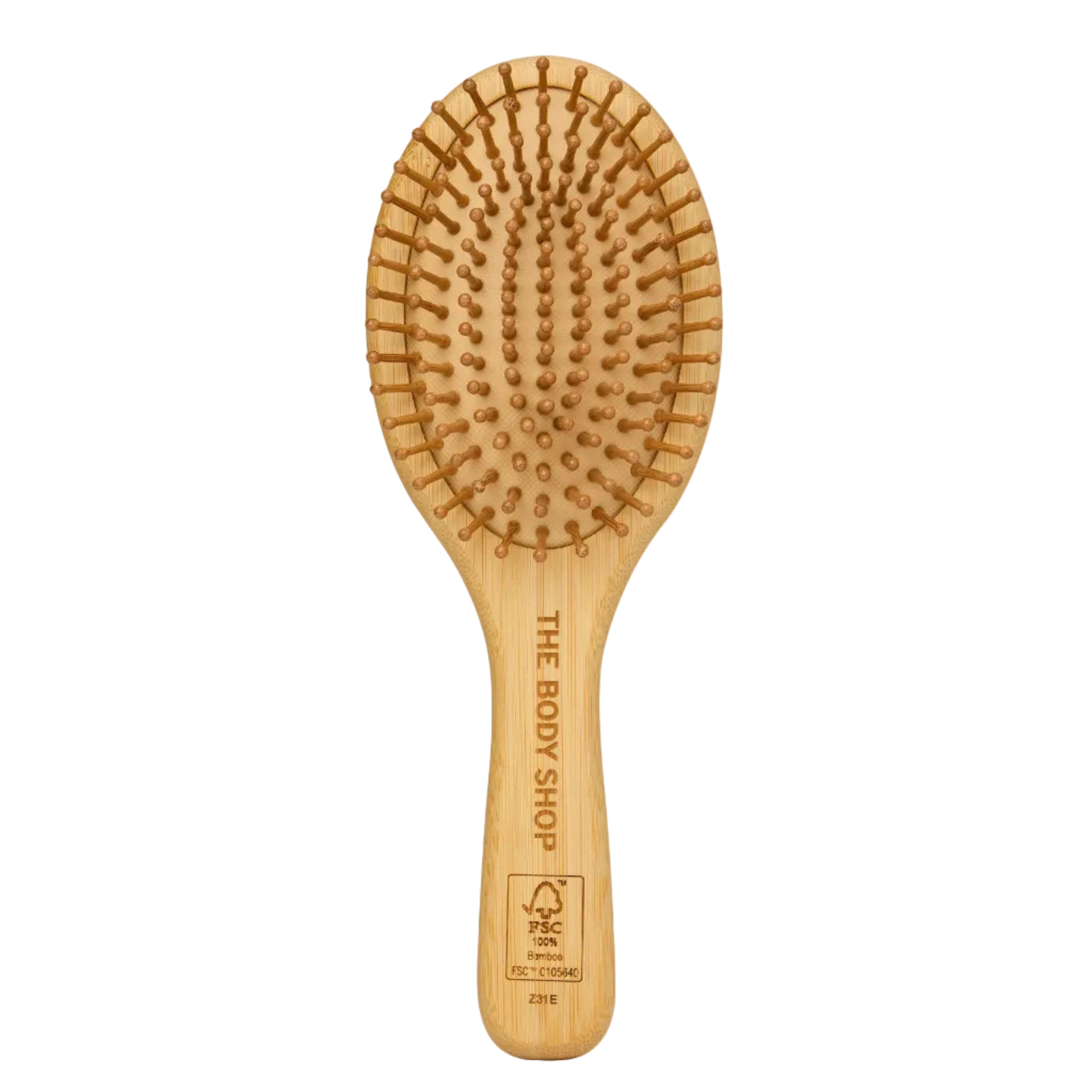 A natural bamboo hairbrush with paddle-shaped bristles and the brand name 'THE BODY SHOP' printed on the handle, set against a solid cream background.