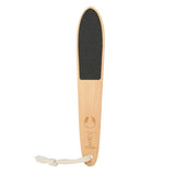 A wooden foot scrubber with a black textured abrasive pad on the top and a white cord tie, shown on a solid light cream background.