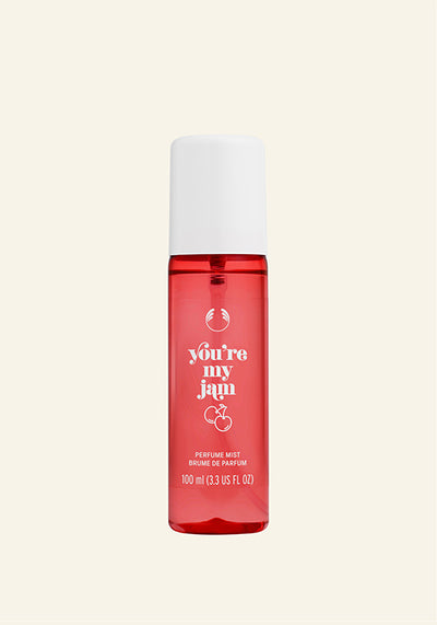 Red perfume bottle with white cap on a beige background